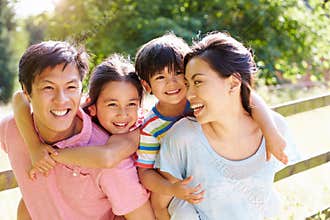 Asian Family Enjoying Walk In Summer Countryside