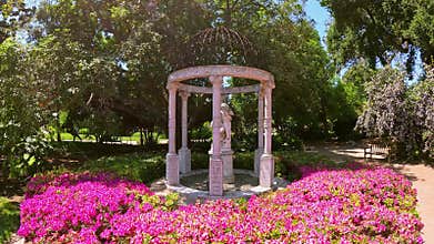 footage of a state surrounded by beautiful pink flowers at Huntington Library and Botanical Gardens in San Marino California