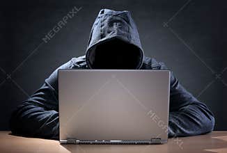 Computer hacker stealing data from a laptop