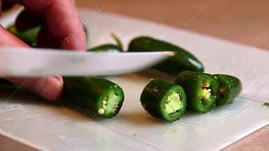 Cutting and chopping fresh green jalapeno peppers