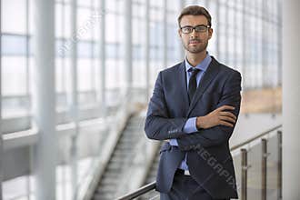 Confident Young Executive Arms Crossed Modern Architecture Escalator Office Building