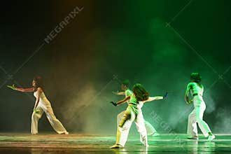 Expressive Contemporary Dancers Reaching Across Green Stage