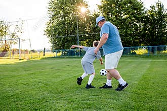 Dad and son sharing passion for football and active lifestyle.