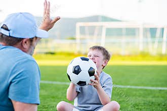 Dad and son sharing passion for football and active lifestyle.