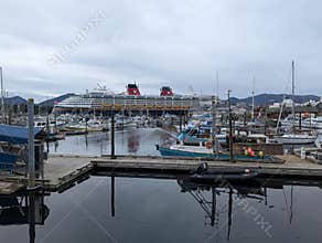 Ketchikan, Alaska 2026.06.13. - Disney cruise ship docked behind a marina with fishing boats and harbor reflections