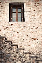 Wooden and glass window in a stone wall with stairs
