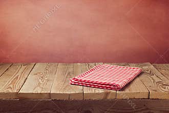 Vintage empty wooden deck table with tablecloth over grunge red background. Perfect for product montage display