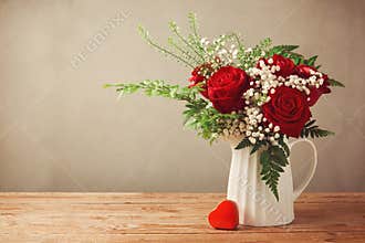 Rose flower bouquet and heart shape box on wooden table with copy space