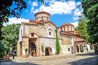 BULGARIA: Medieval stone Orthodox church with red tile roof under blue sky
