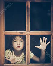 Sad child looking out the window