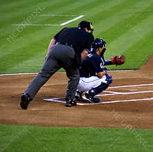 Plate umpire and catcher warmng up with pitcher