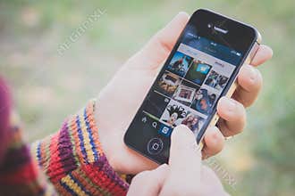 Hand holding Iphone and using Instagram application