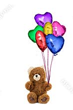 Teddy bear holding colorful heart shaped balloons.