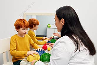Occupational therapist due sensory integration therapy to improve sensory processing for male child patient. Doctor using