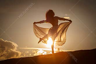 Beautiful woman dancing at sunset