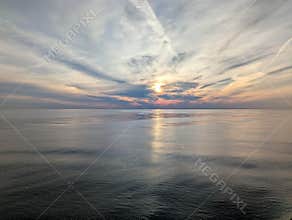 Colorful sunset over calm ocean with dramatic cloud formation
