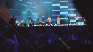 Audience with hands raised at a music festival concert