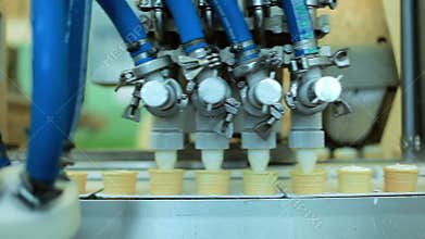 Food processing equipment. Waffle cones filling with ice cream. Production line
