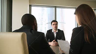 Male job applicant at job interview, handshaking, talking introducing himself