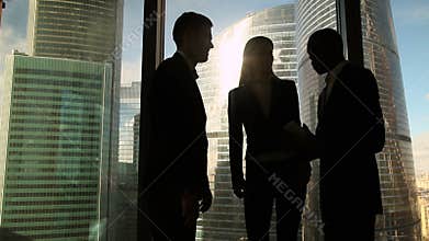 Three multicultural business people starting meeting in office, greeting handshake