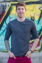 Handsome male teenager tattooed arm in grey shirt