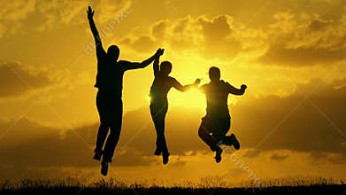 Family running at sunset and jumping up raising their hands winners