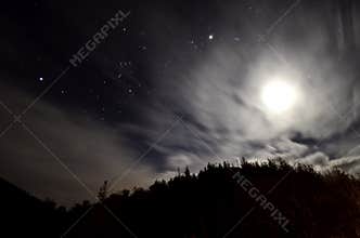 Cloudy night with stars and moon