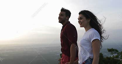 Couple at mountain top holding hands, latin man and woman enjoy morning view