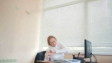 The manager-woman was hurt when working at the desk in the office. Back pain