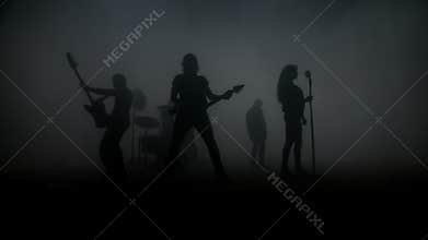 Rock band silhouettes performing rock concert on stage. Rock music band