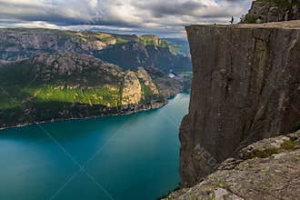 Preikestolen - landscape of tourists at the top of spectacular Pulpit Rock cliff and surrounding fjords, Norway