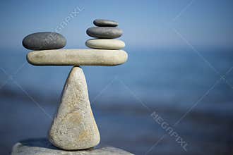 Balance of stones. To weight pros and cons. Balancing stones on the top of boulder. Close up.