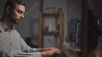 Dolly shot of serious computer programmer working in the office