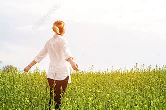 The beauty of a girl outdoors, enjoying nature and freedom and enjoying life. Beautiful girl in a white shirt, strolls