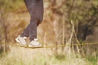 Slacklining is a practice of balancing, in which nylon or polyester fabric stretched between two anchor points is