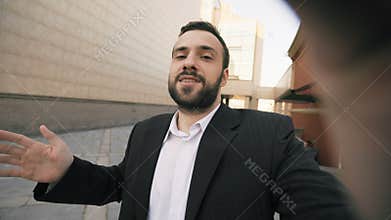 Young bearded business man talking smartphone having video chat business meeting. Businessman using app to have video