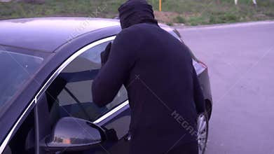 Robber with a crowbar near the car door