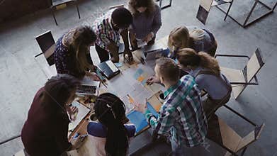 Brainstorming if creative mixed race group of people at modern office. Top view of group of people standing near table.