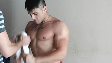 Muscular young man exercising with assistant