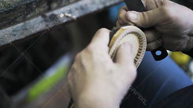 Man shoemaker cutting shoe sole leather with knife