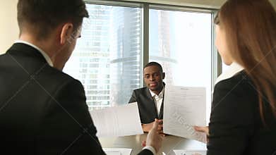 Successful african candidate hired after job interview, handshaking, signing papers
