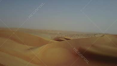 Drone view of sand dunes at sunrise.