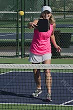 Pickleball - Smiling Female Hitting Ball At Net