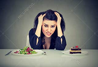 Woman tired of diet restrictions deciding to eat healthy food or cake she is craving
