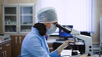 Side view of scientist using microscope