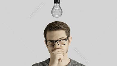 Clever creative man think gets an idea, which lights up a symbolic lamp over his head on white background