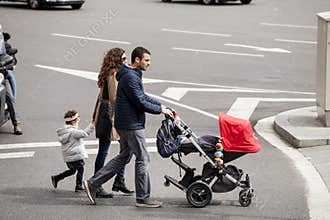Whole family with stroller walking on the road. Barcelona, Spain
