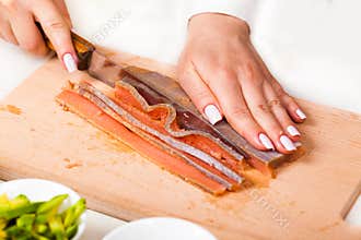 Chef cuts the fillet of red fish closeup