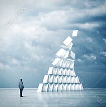 Businessman looks at house of cards. 3d rendering