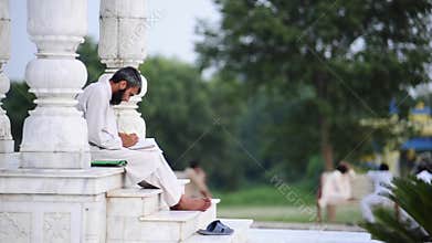 Arab man reading and writing from book. Islamabad. Pakistan